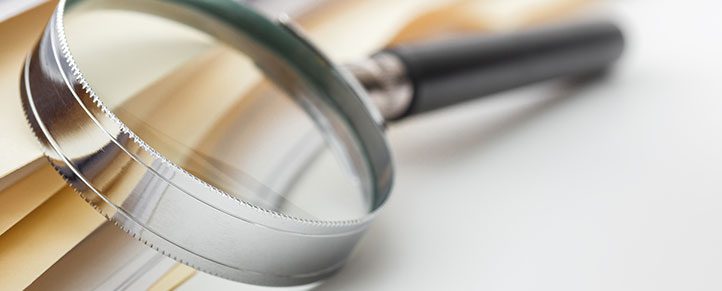 Magnifying glass on open book pages.