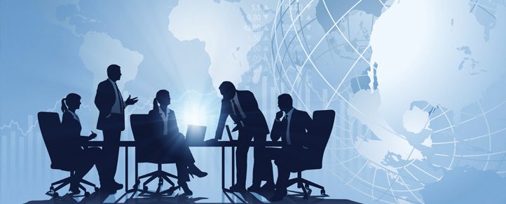 Silhouetted business meeting with world map background.