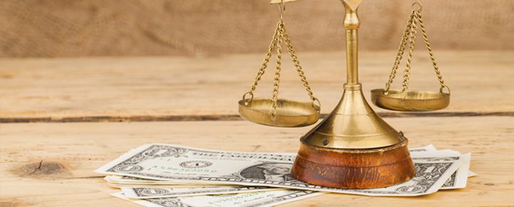 Scales and dollar bills on wooden surface.
