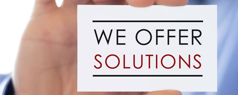 Hand holding card with "We Offer Solutions".
